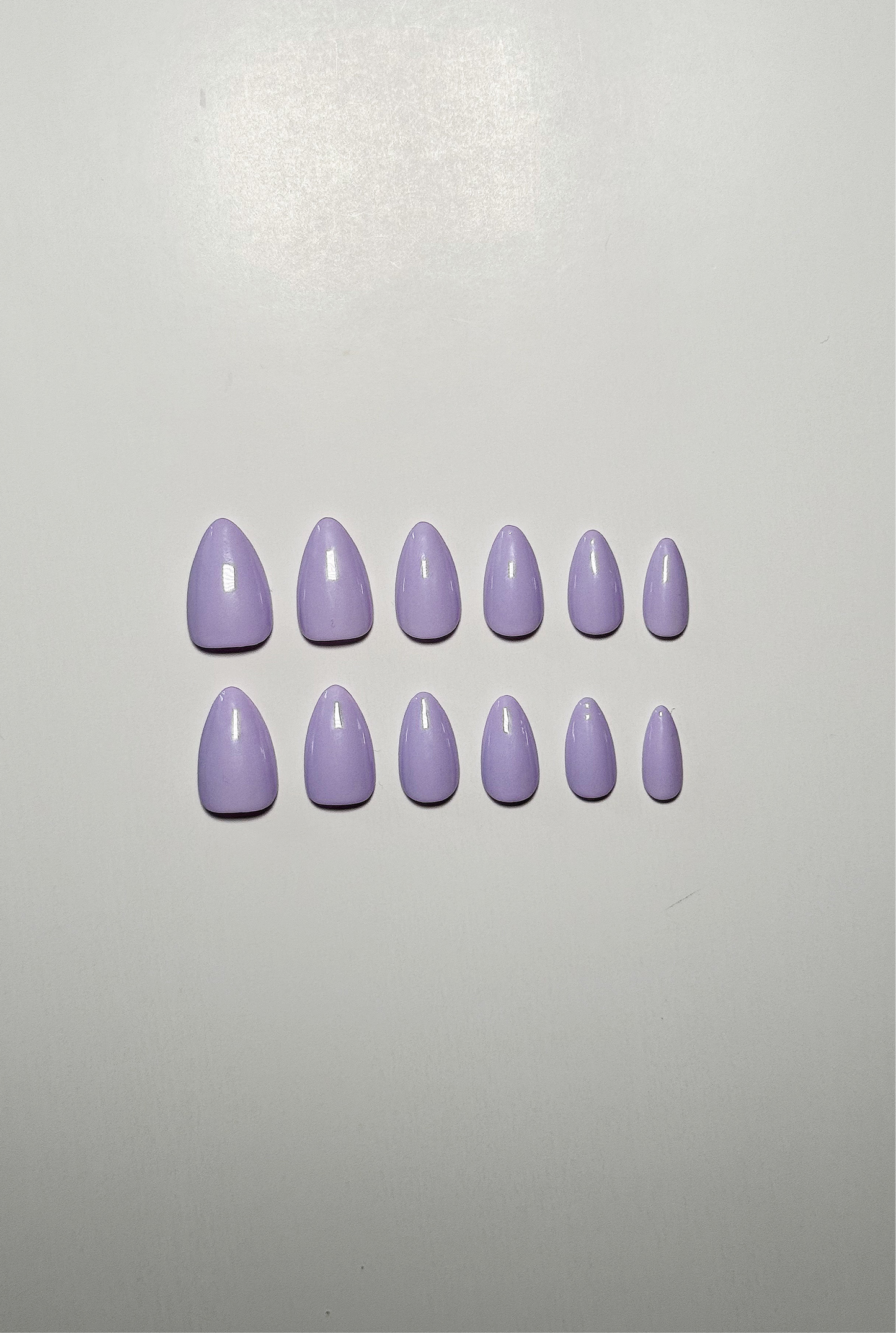 Light purple or lavender, short to medium length, almond shaped press on nails.