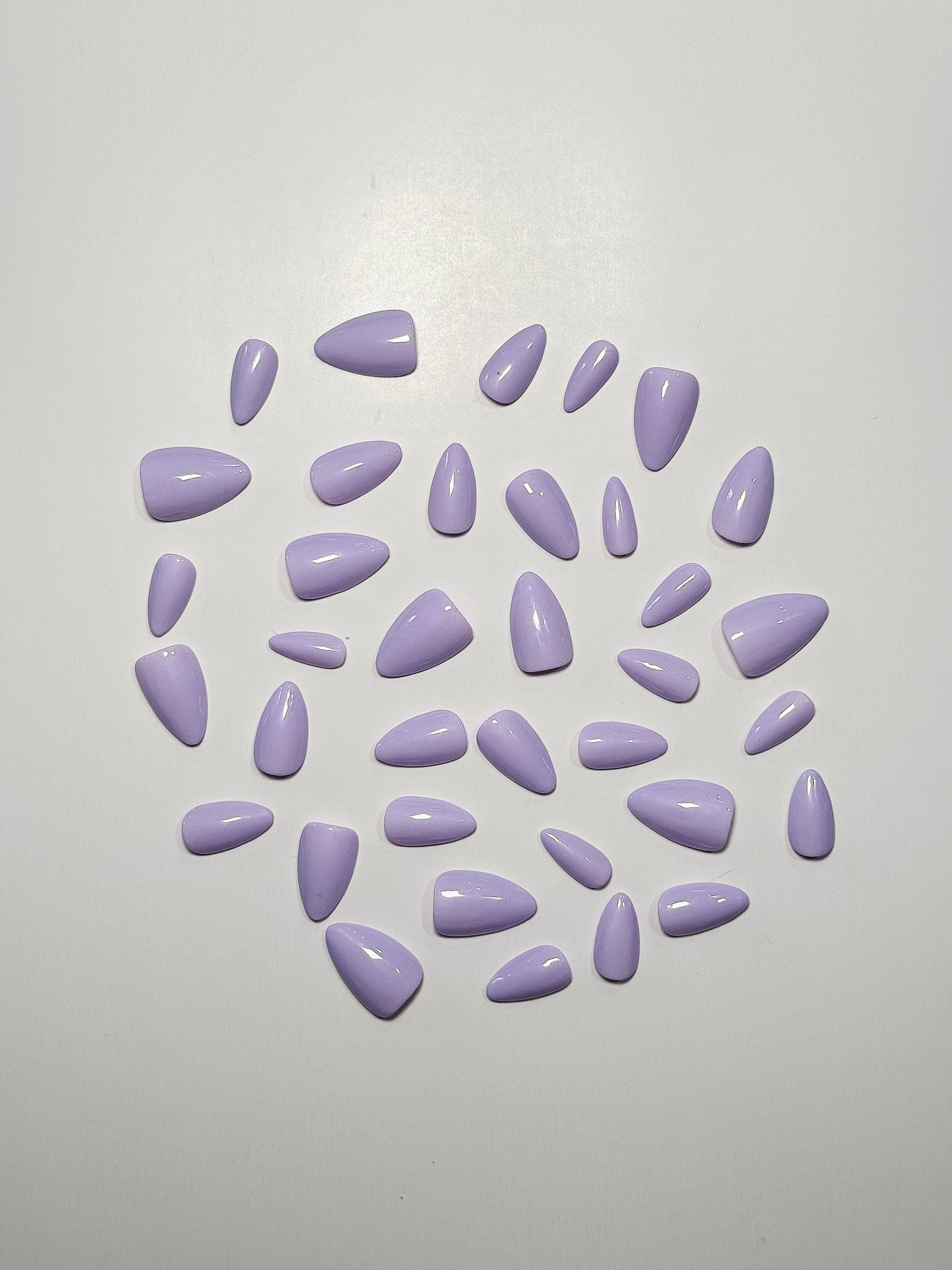 Light purple or lavender, short to medium length, almond shaped press on nails.