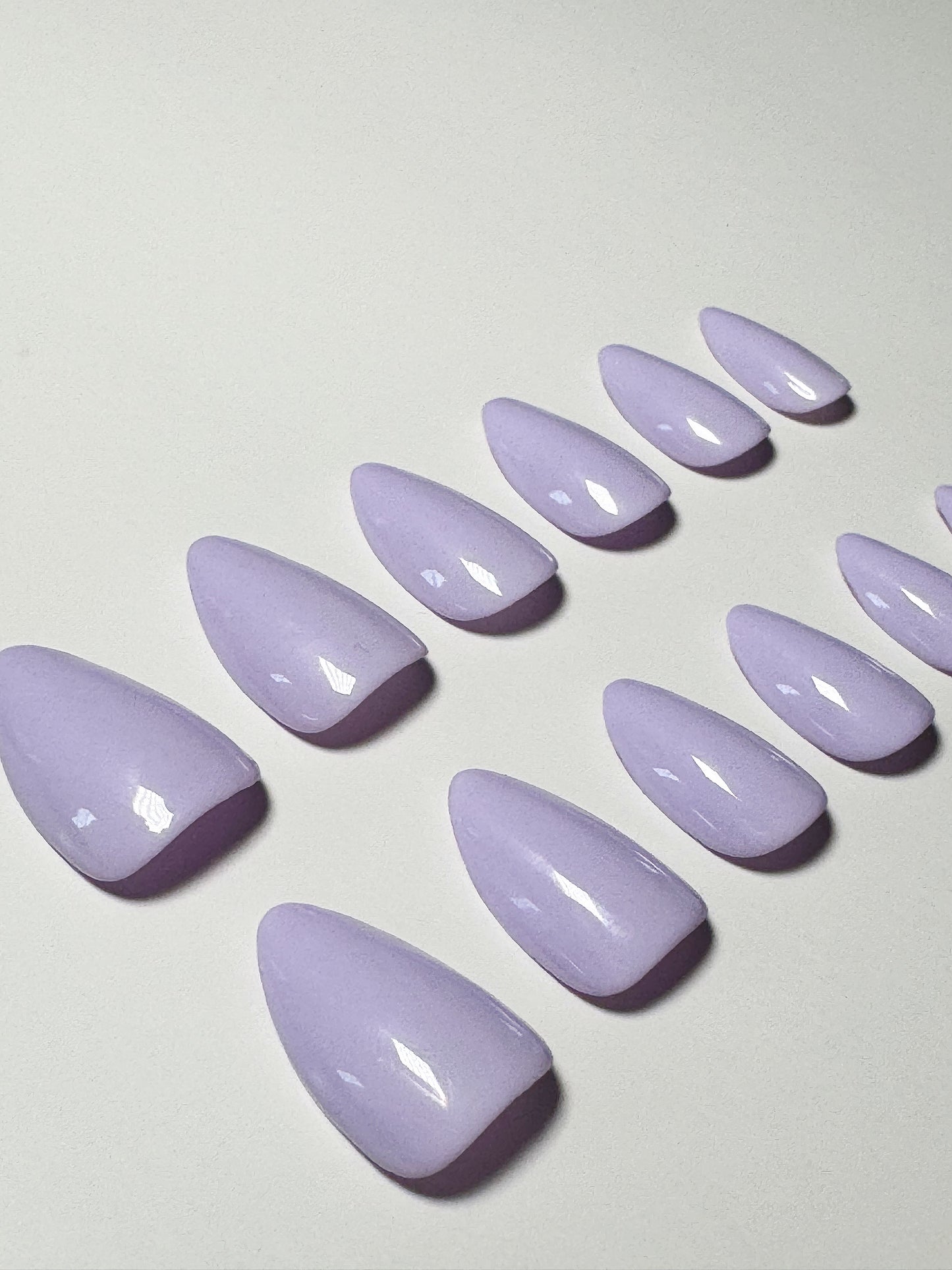 Light purple or lavender, short to medium length, almond shaped press on nails.