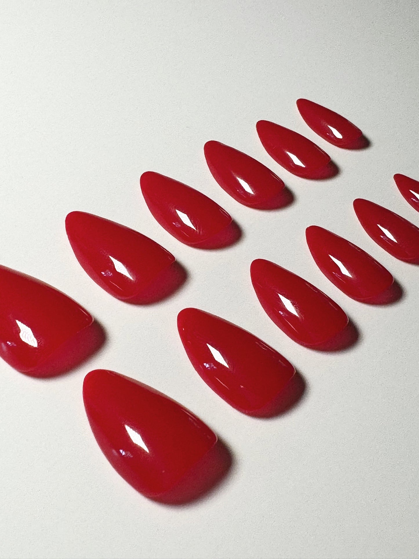 Classic red, short to medium length, almond shaped press on nails.