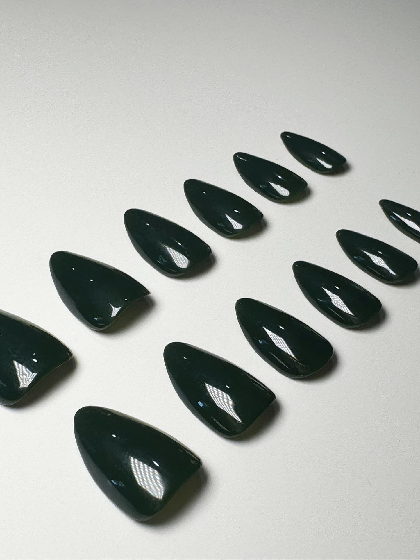 Dark forest green, short to medium length, almond shaped press on nails.