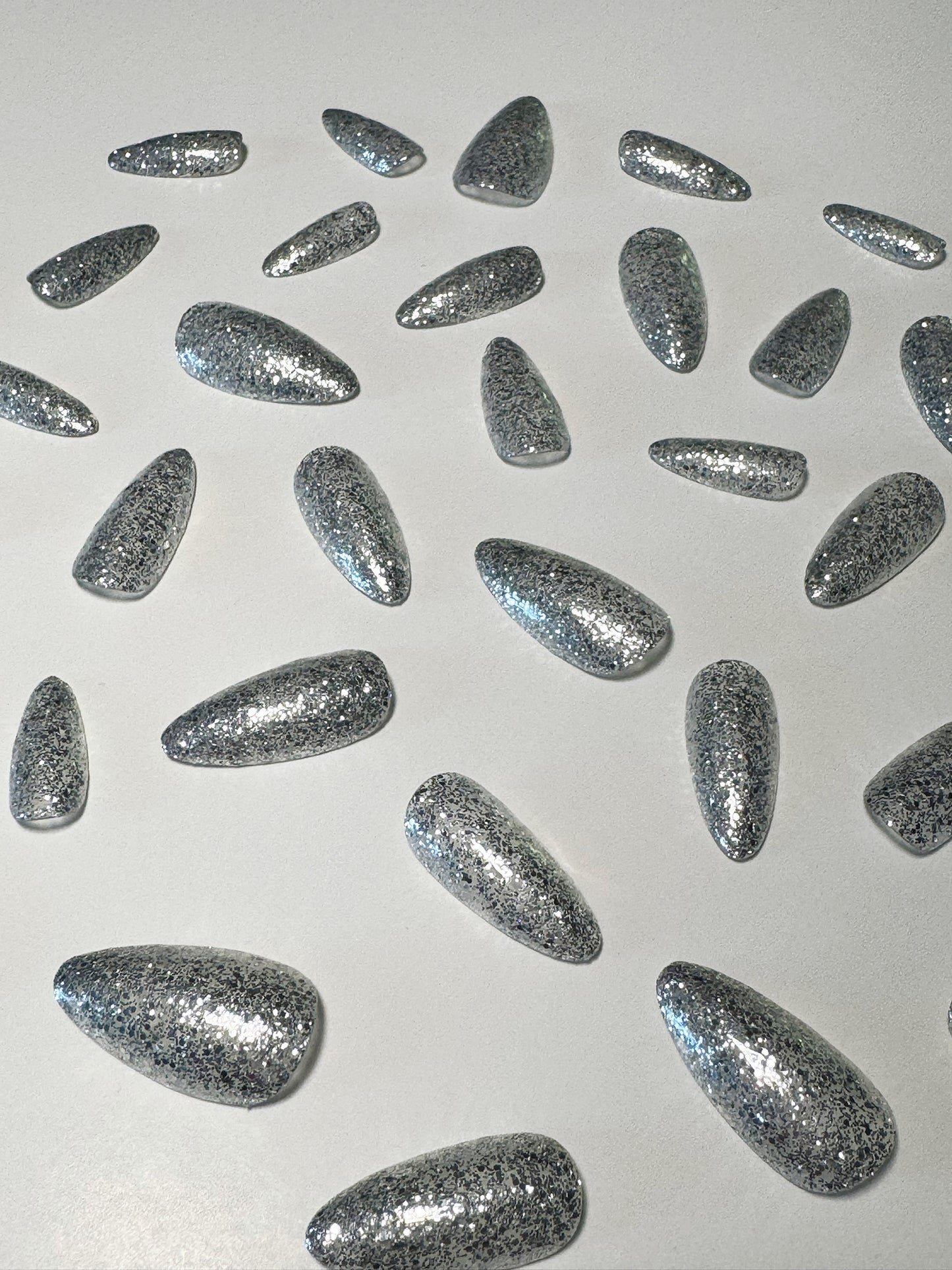 Silver glitter, medium to long length, almond shaped press on nails.