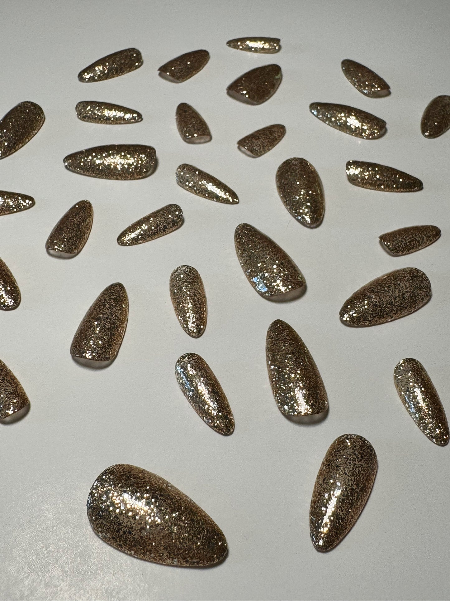 Gold glitter, medium to long length, almond shaped press on nails.